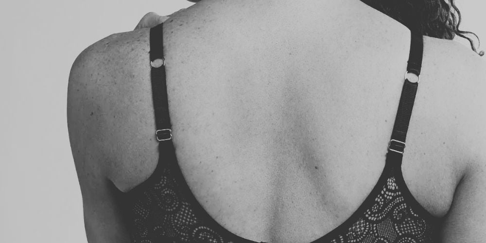 close-up on woman back with a hand try to take her bra off by