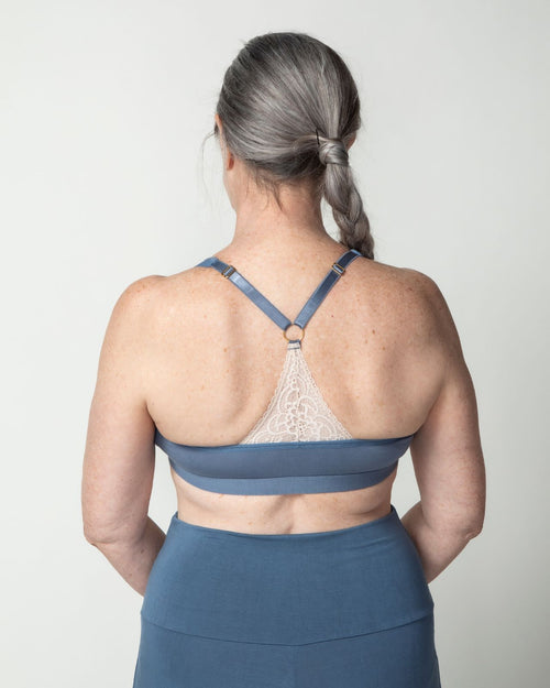 Slate / Mastectomy & pocketed front closure lace racerback bra with a plunging neckline and soft wire free cups on mastectomy model with breast forms.