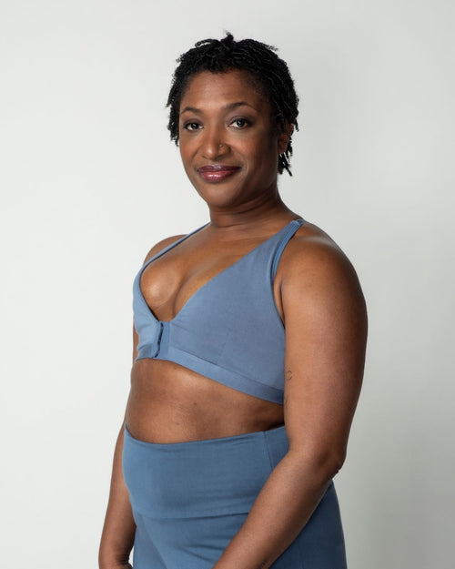 Slate / Implants & pocketed front closure lace racerback bra with a plunging neckline and soft wire free cups on implant reconstruction model.
