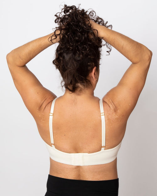 Ivory / Implants & pocketed plunge t-shirt bra with soft wire free cups, back hook closure and adjustable straps on implant reconstruction model.