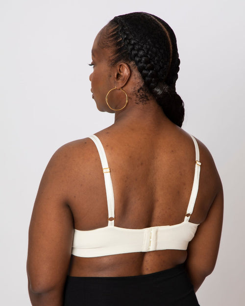 Ivory / Implants & pocketed plunge t-shirt bra with soft wire free cups, back hook closure and adjustable straps on implant reconstruction model.