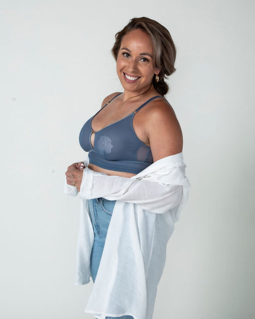 Slate / Implants & model wearing the Victoria Pocketed Keyhole bralette with gold lace trim and gold jewel that says anaono