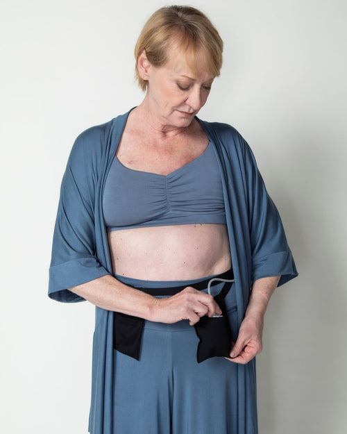 Slate  & Model holding the additional drain belt pocket while wearing the Miena post surgery super soft robe